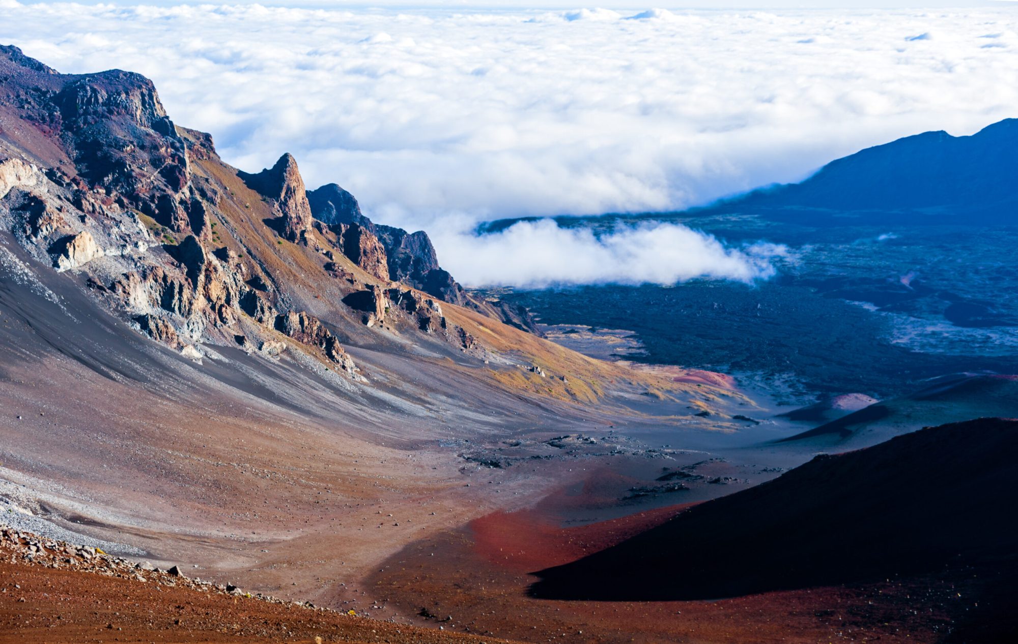 Volcanic crater with rocky slopes under a cloudy sky
